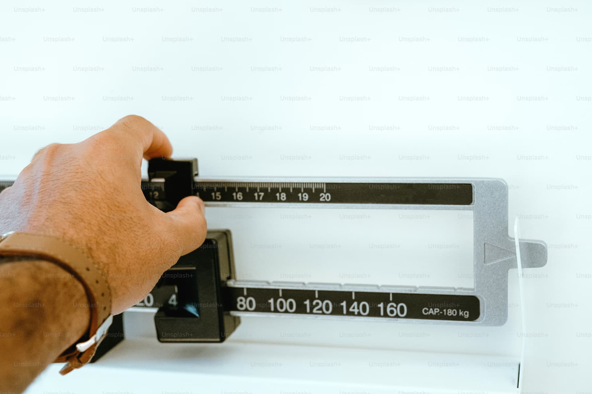 Picture of a hand moving a sliding weight on a balance scale